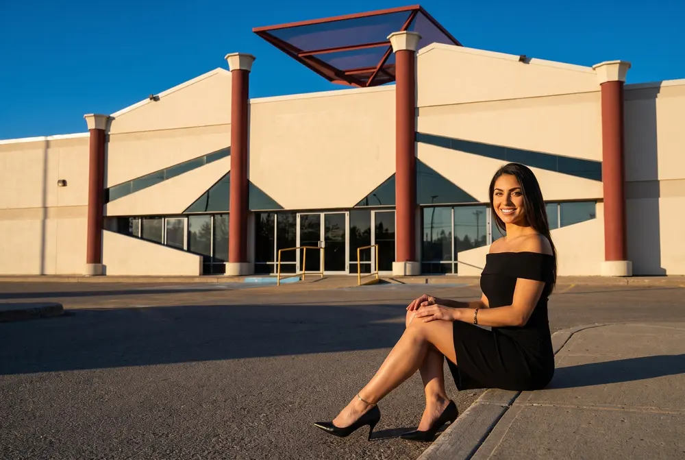 A woman outside ACE Casino Red Deer at golden hour