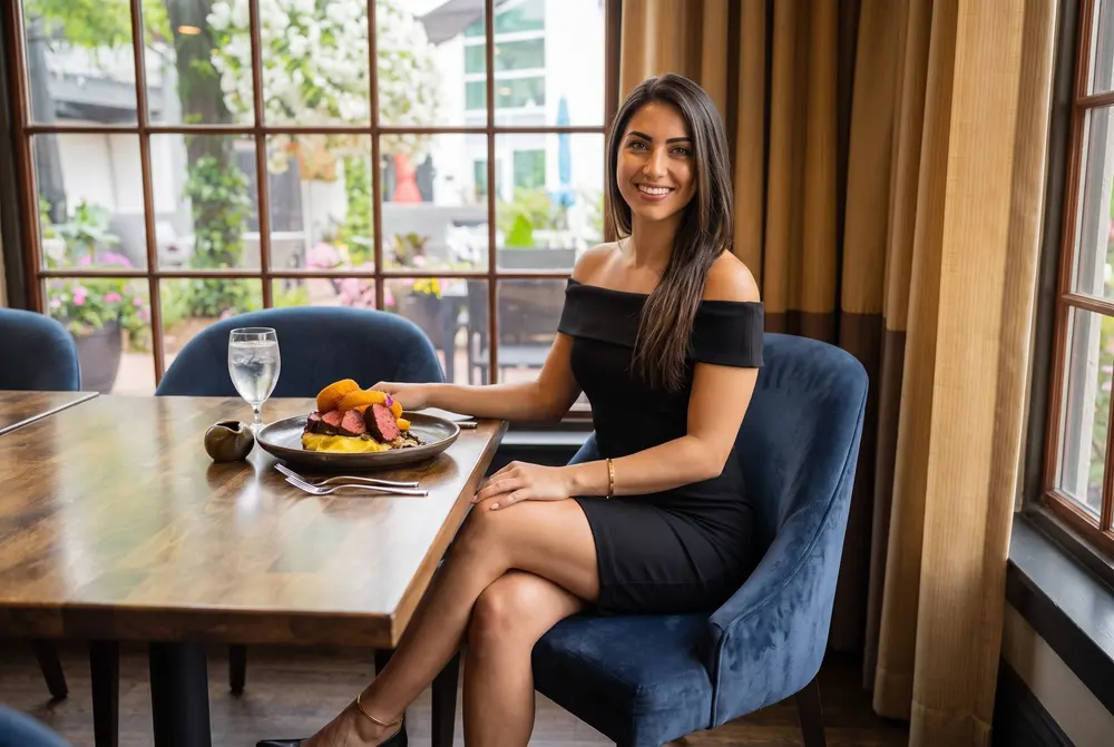 A woman with a steak dinner on the Garden Terrace