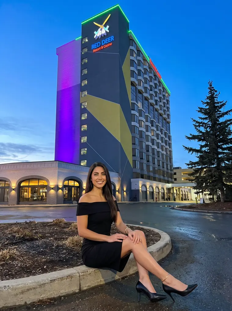 A woman outside Red Deer Resort & Casino at dusk